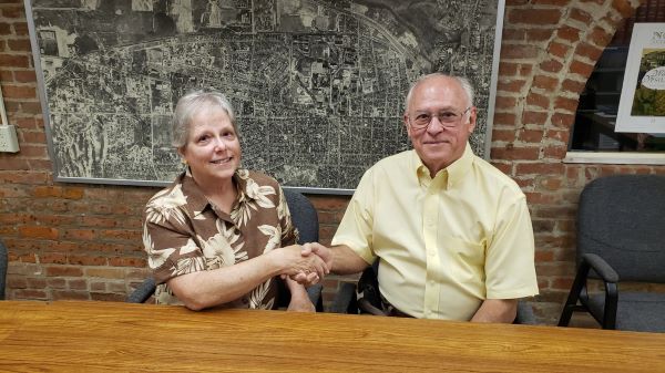 Nancy Howard and Dave Brough, co-presidents, seated at table in front of map